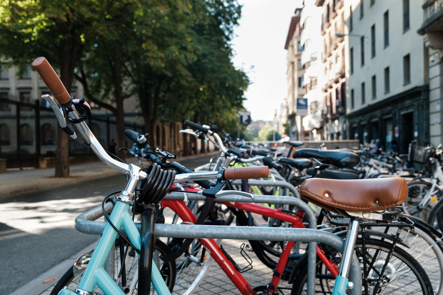 Rack with a lot of bikes in a street of Pamplona, Spain. Old vintage cycle in the foreground. Sunny day, sustainability and healthy commute. Ecology and free contamination concept.